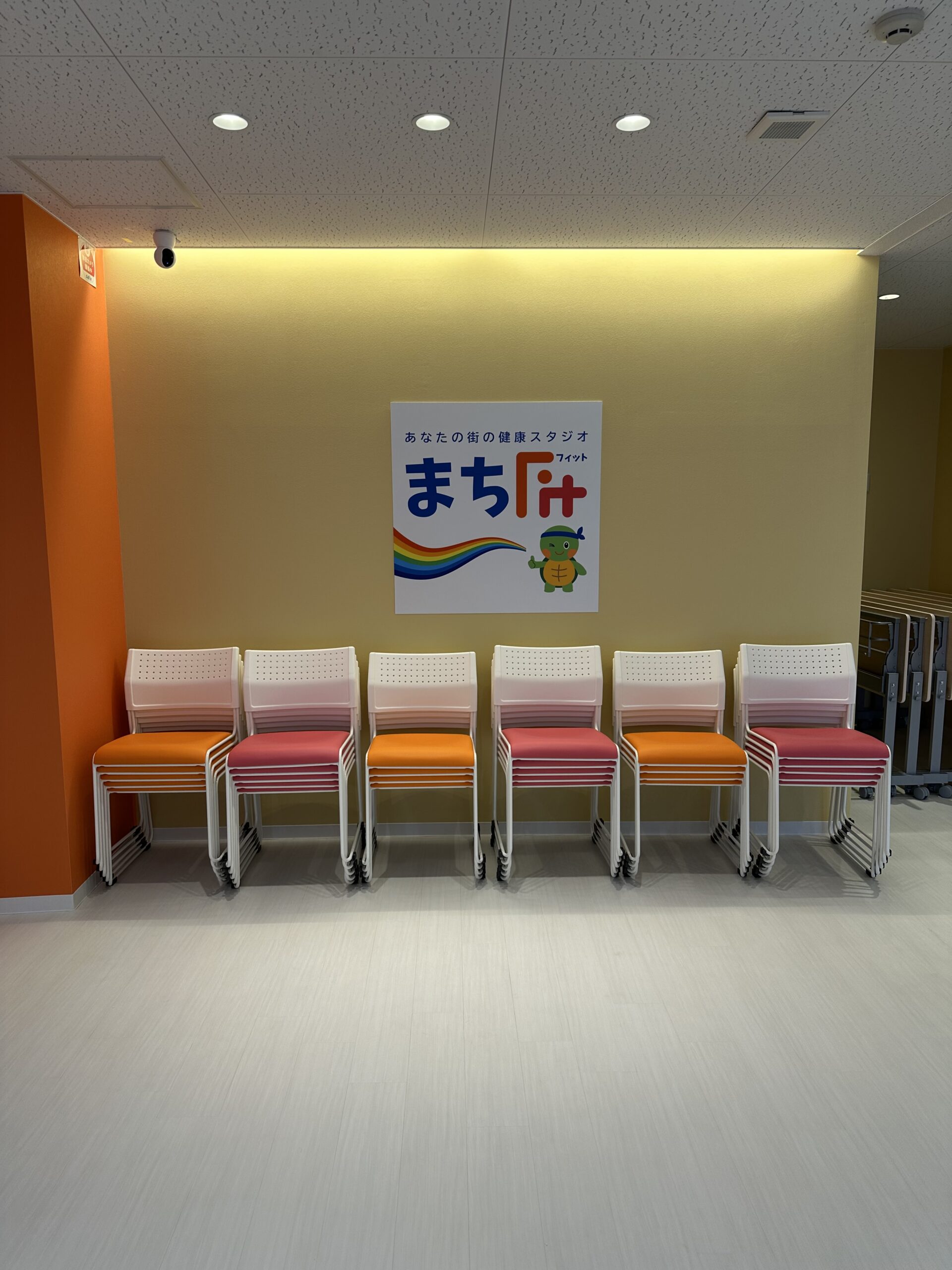 スタジオ内のチェア収納とまちFitロゴ